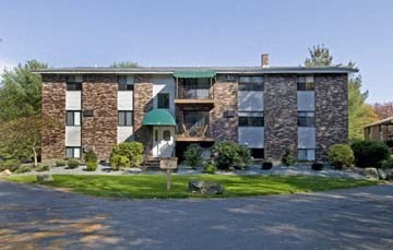 the front of a brick building with a green roof
