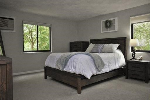 a bedroom with a bed and two windows