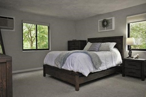 a bedroom with a bed and two windows