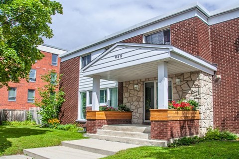 the front of a brick building with steps and a porch