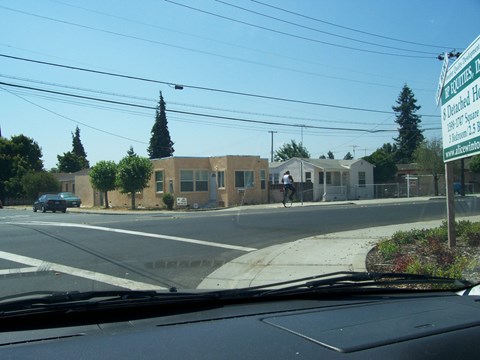 a building on the corner of a city street with a cross walk