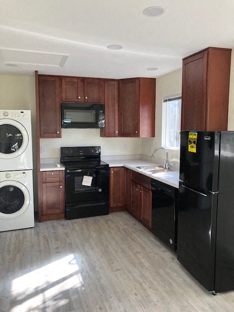 A black refrigerator is in a kitchen with wooden cabinets.