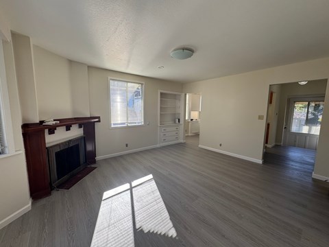 A living room with a fireplace and a grey floor.