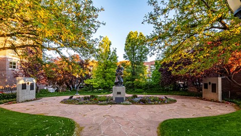 a statue in the center of a courtyard on the campus