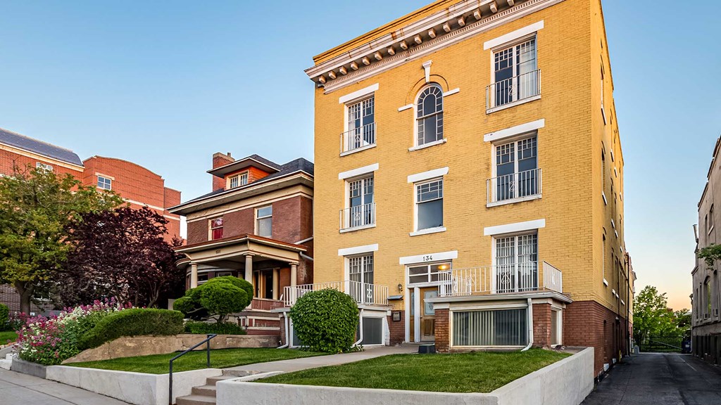 Side exterior view of yellow First Avenue Home
