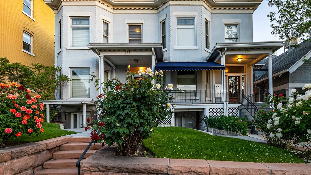 Front exterior of light blue First Avenue Home with a view of front yard