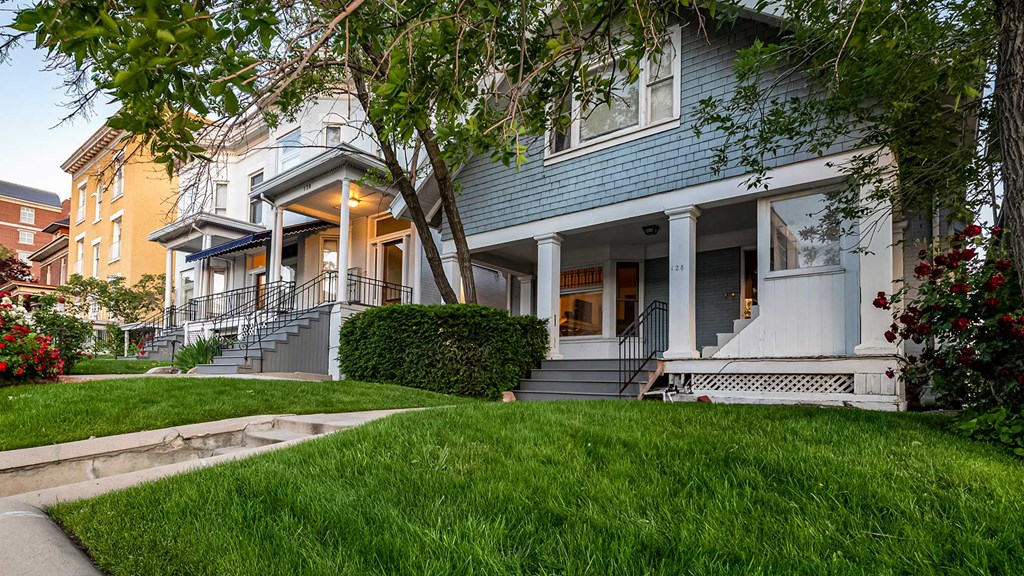 Side exterior view of blue and white First Avenue Home with a view of front yard