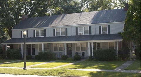 A house with a porch and a lamp post in front.