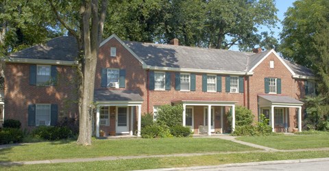 A red brick house with a white door and windows.