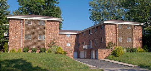 A large red brick building with a driveway in front.