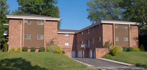 A red brick building with a driveway in front.