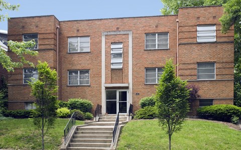 A red brick building with a white door and windows.