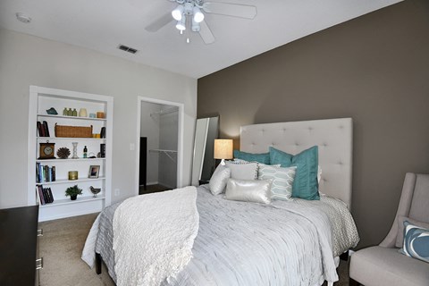 A bedroom with a large bed and a ceiling fan.