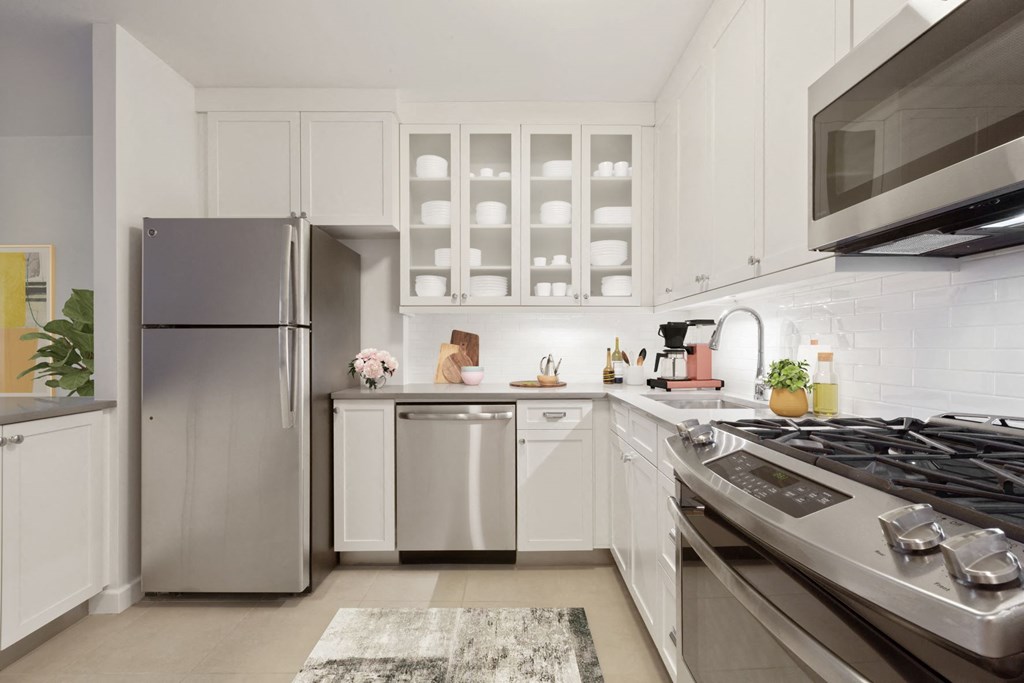 a modern kitchen with stainless steel appliances and white cabinets
