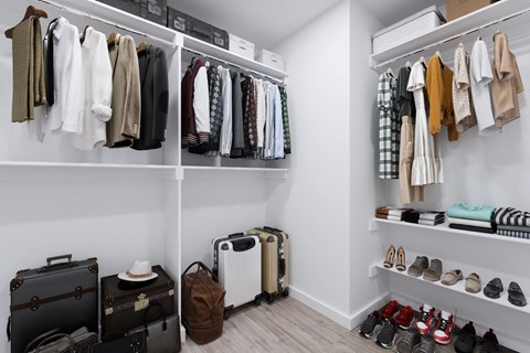 a closet with luggage and shoes in it