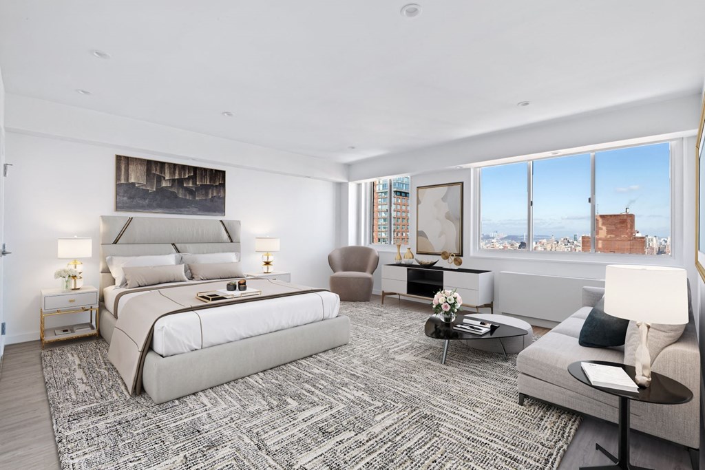 a white bedroom with a large bed and a large window