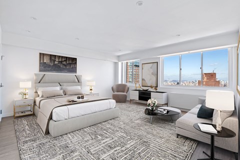 a white bedroom with a large bed and a large window