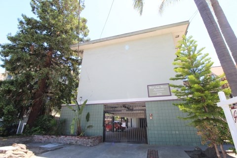 A white building with a green tiled wall and a sign that says "Café".