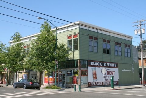A car is parked on the street in front of a Black & White restaurant.