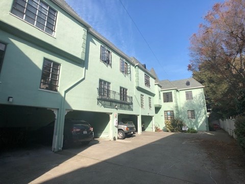 a green building with cars parked in front of it