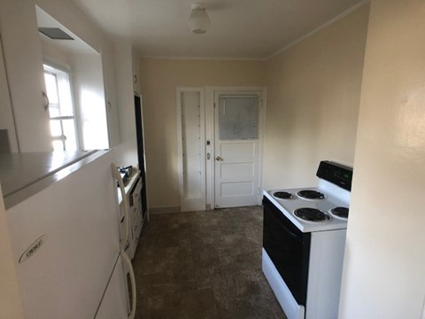 a kitchen with a stove and a white door