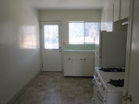 A kitchen with white appliances and cabinets.