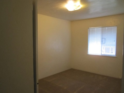 A room with a window and a light on the ceiling.
