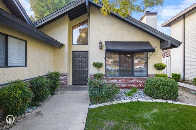 A house with a black door and a small front yard.