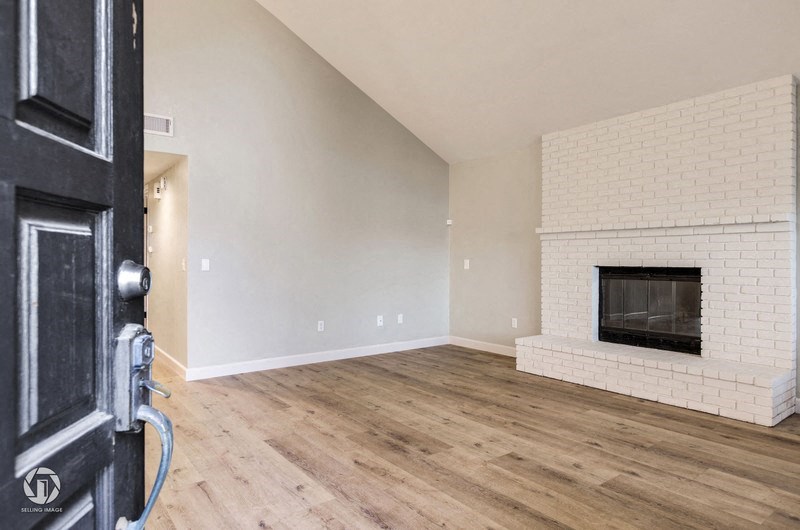 A room with a fireplace and wooden floors.
