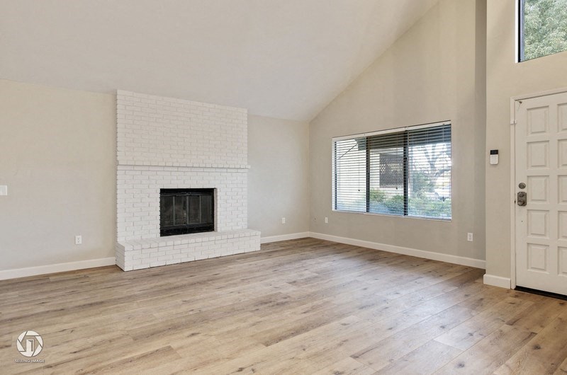 A spacious living room with a fireplace and wooden flooring.