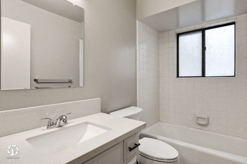 A white bathroom with a sink, toilet, and bathtub.
