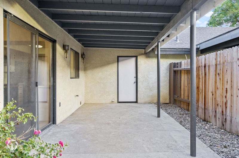 A patio with a door and a wall.