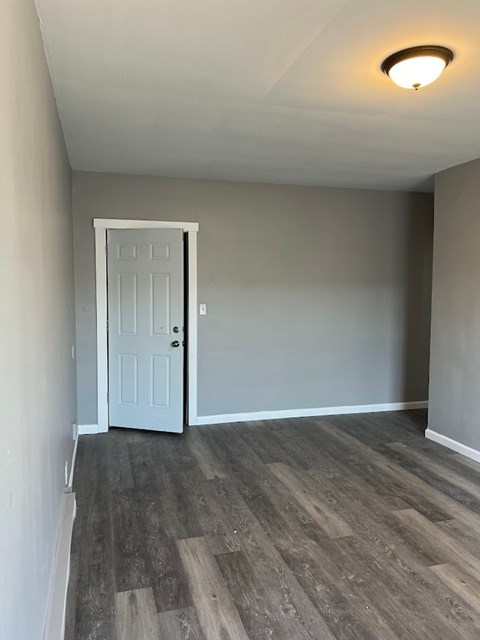 A room with a white door and grey walls.