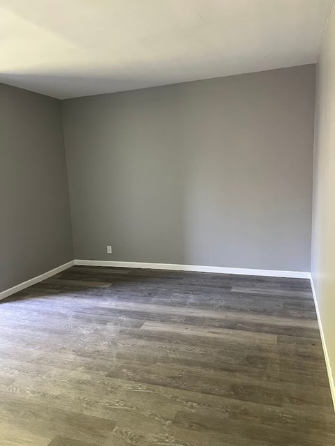 A room with a wooden floor and a wall.