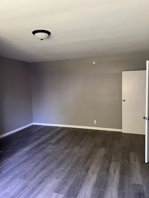A room with a grey floor and a white door.