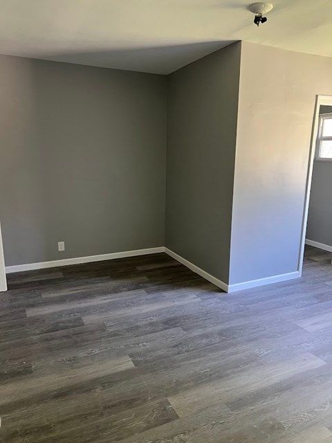 A room with wooden flooring and a white door.