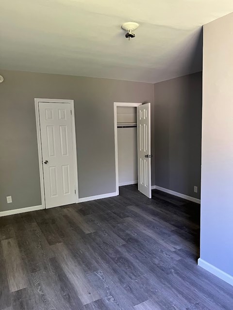 A room with a white door and a grey door.