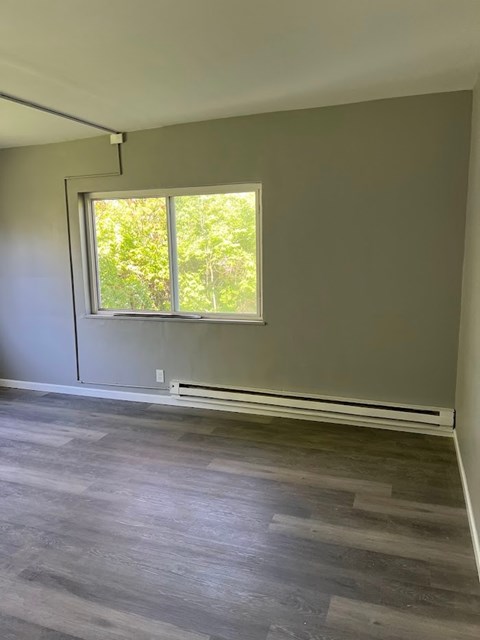 A room with a window and a grey floor.