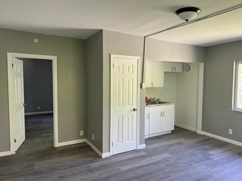A room with a white door and a grey floor.