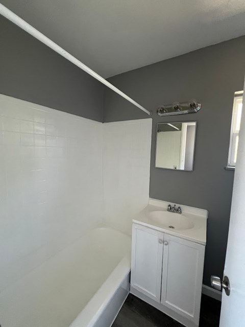 A white sink in a bathroom with a grey wall.