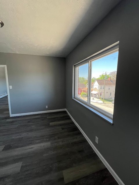 A room with a large window and grey walls.