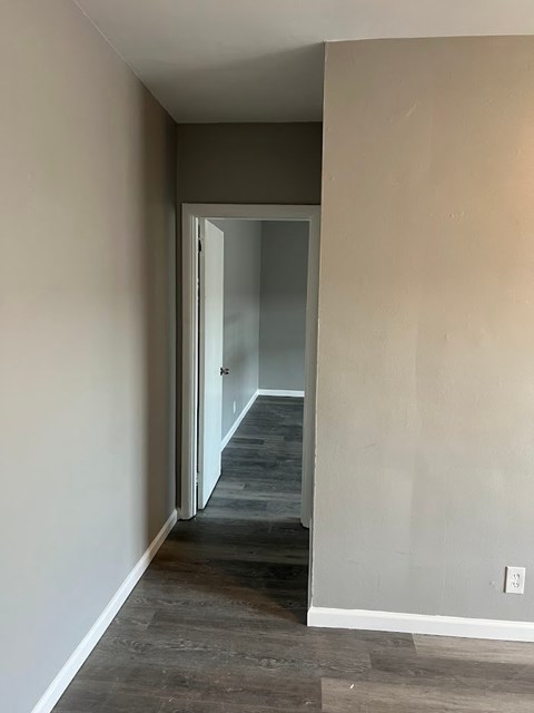 A hallway with a doorway leading to another room.