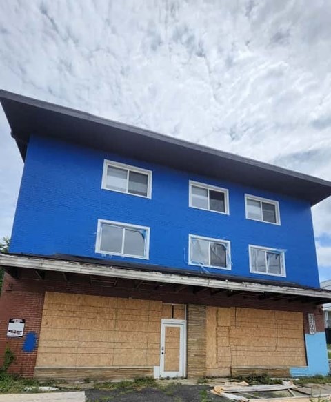 A blue house with a white door and windows.