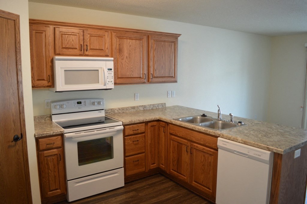 a kitchen with white appliances and wooden cabinets