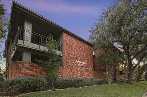 A red brick building with a balcony on the second floor.