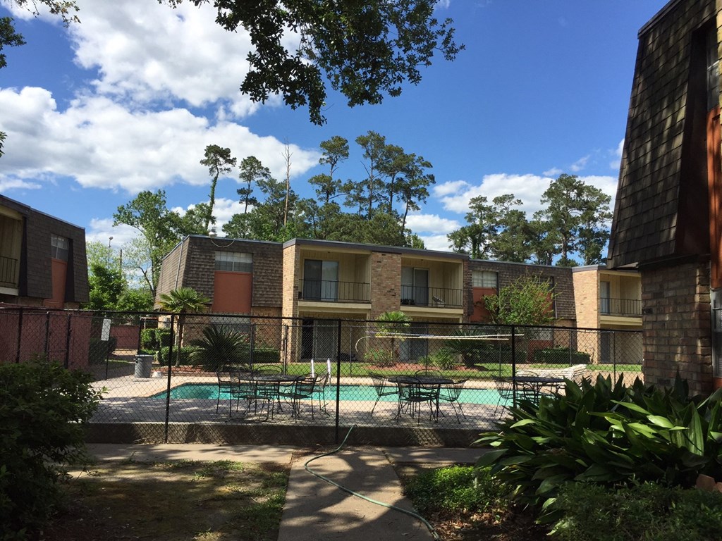 an apartment building with a pool in the courtyard