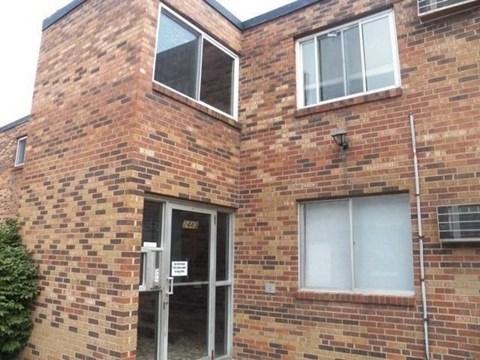 A brick building with a door and windows.