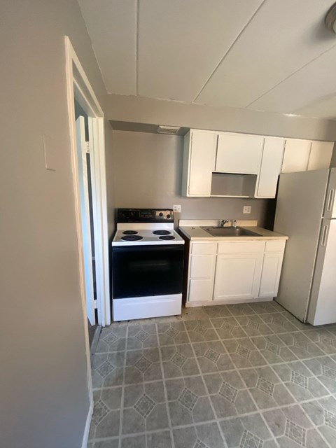 A kitchen with white cabinets and a black oven.