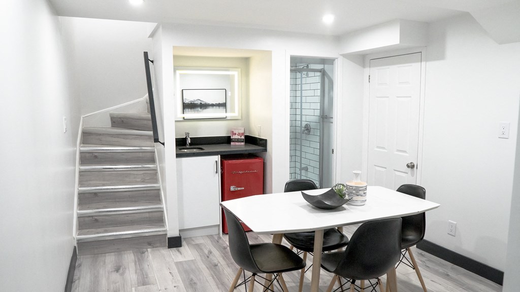A dining room with a white table and chairs.