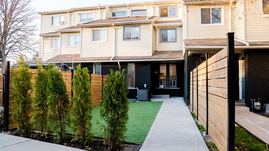 A modern apartment complex with a green lawn in front.